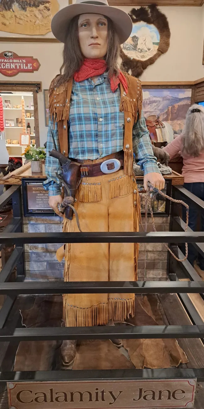 Statue of cowgirl in Western attire.