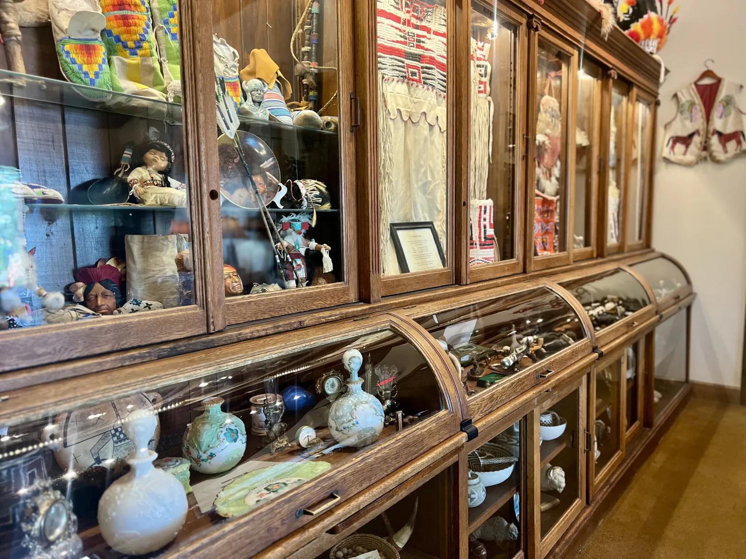 Wooden display cabinet with various cultural artifacts.