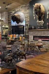 Rustic room with bison and fireplace decor.