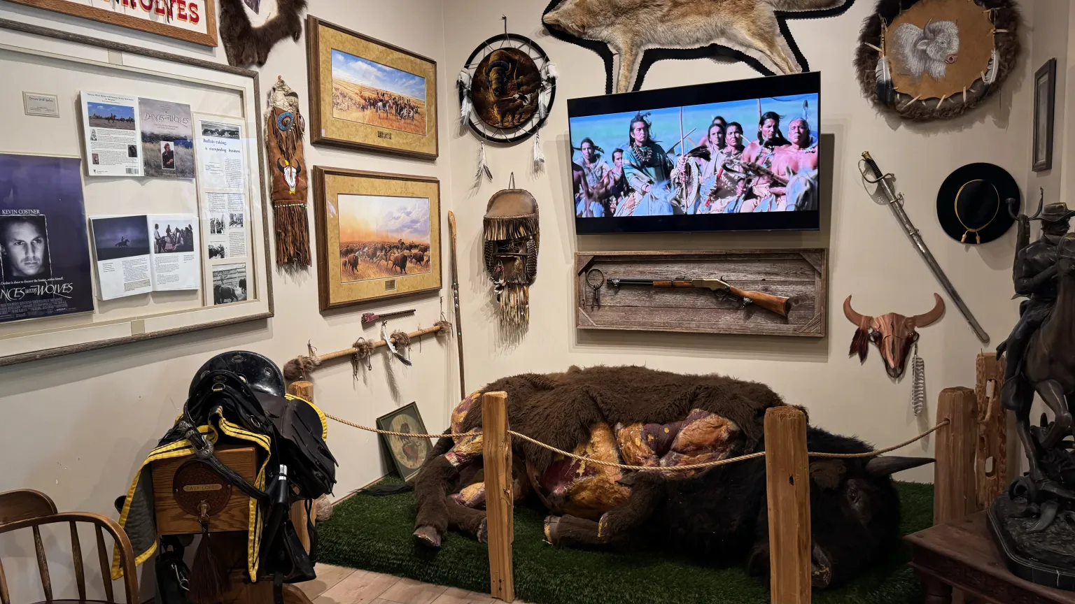Museum display with artifacts and video screen.