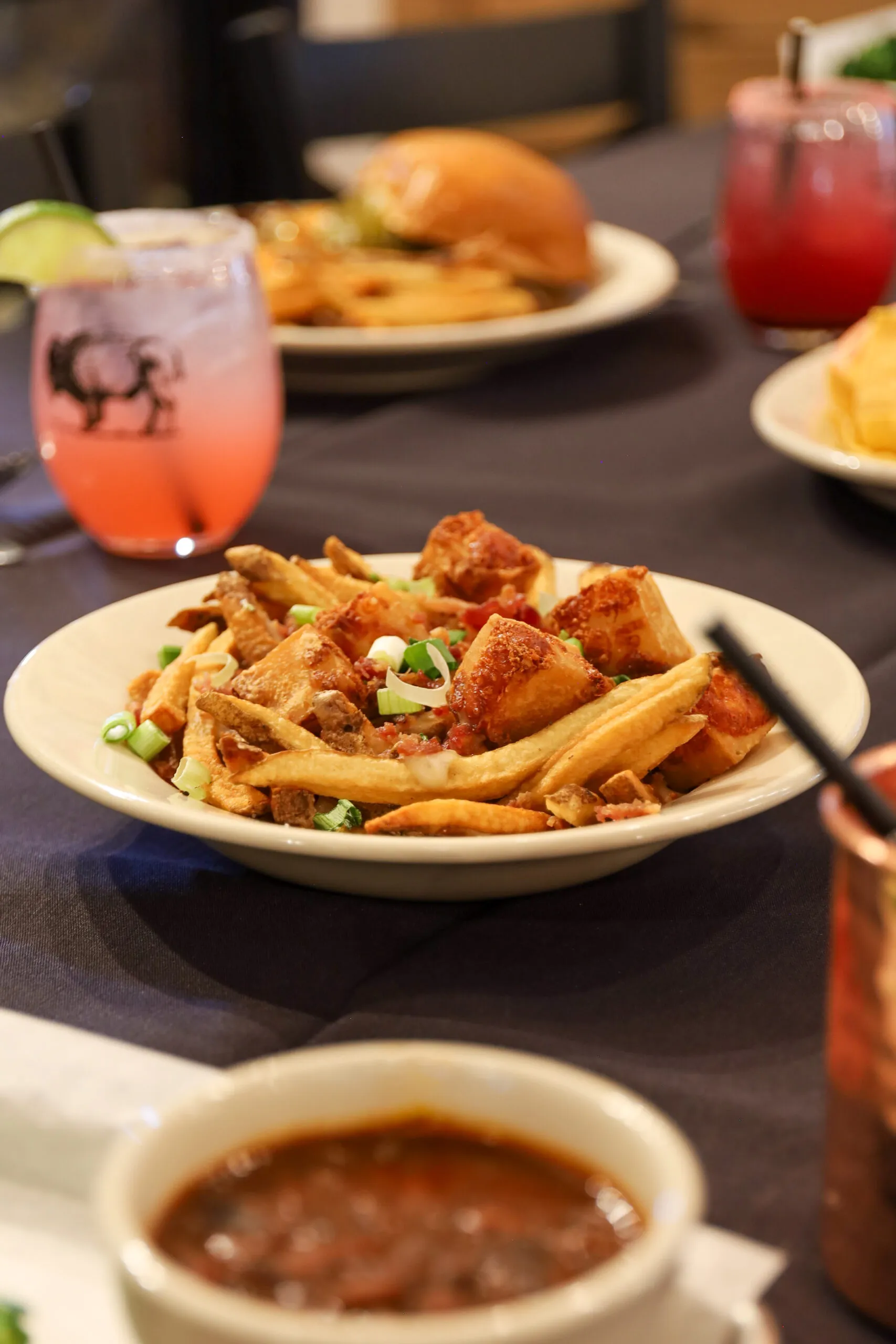 Plate of fries with drinks and burger.
